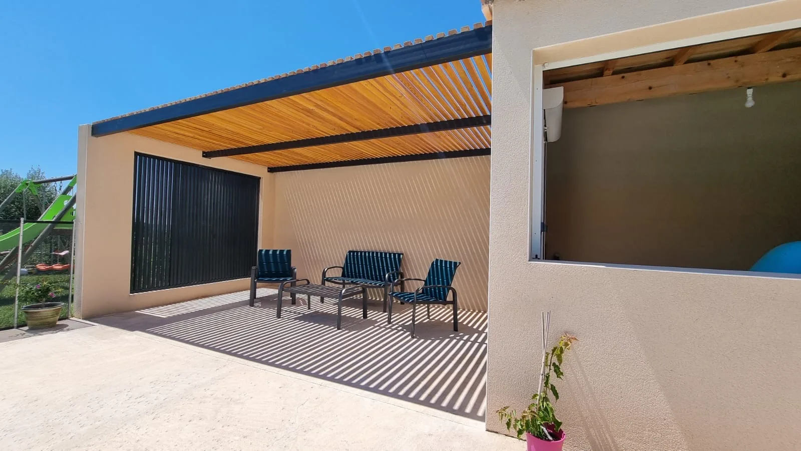 Terrasse couverte du pool house sous la pergola sur mesure, ombres du claustra bois Douglas sur le sol et les murs, Caveirac (Gard)