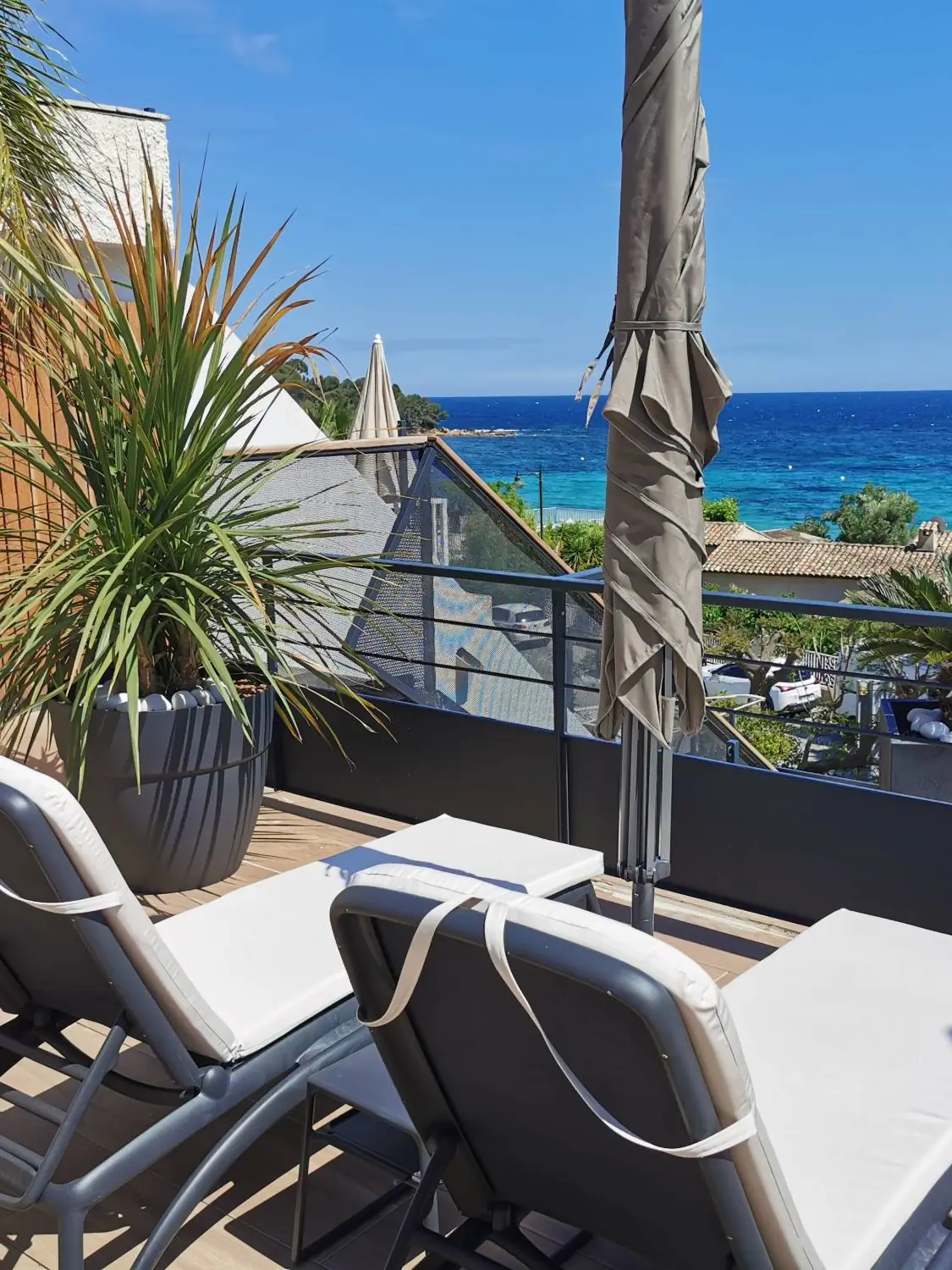 Transats sur le rooftop de l'hôtel Les Alcyons au Lavandou, garde-corps acier anthracite et vue sur la mer